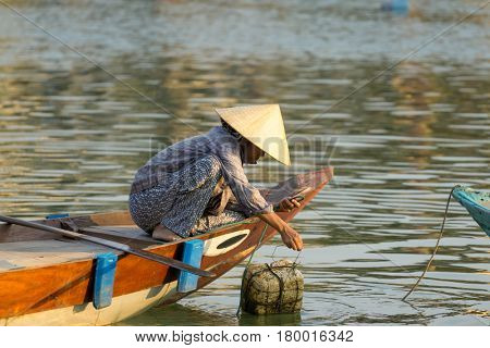 Hoi An Vietnam - February 20 2017 - The boatwoman  on the old national vietnamese boat down the Thu Bong river.