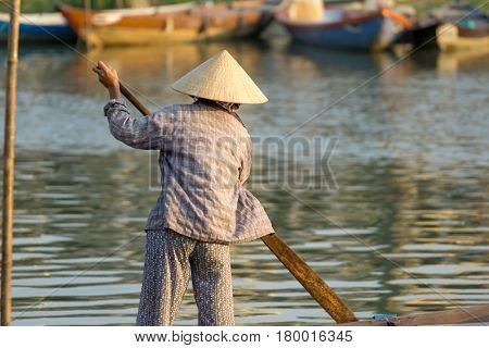 Hoi An Vietnam - February 20 2017 - The boatwoman  on the old national vietnamese boat down the Thu Bong river.