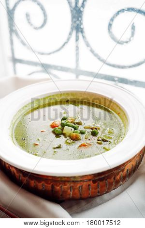Vegetable soup with peas over vintage background
