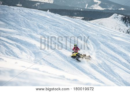 Rider on the snowmobile in the mountains ski resort in Amut Russia.