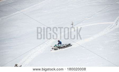 Rider on the snowmobile in the mountains ski resort in Amut Russia.