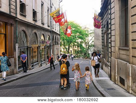 Family At Street With Flags On Hotel Ville At Geneva