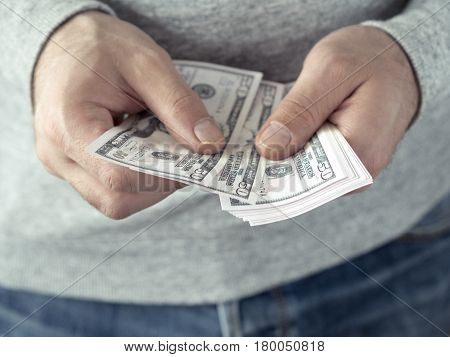 Hands counting dollars. Selective focus. Shallow DOF