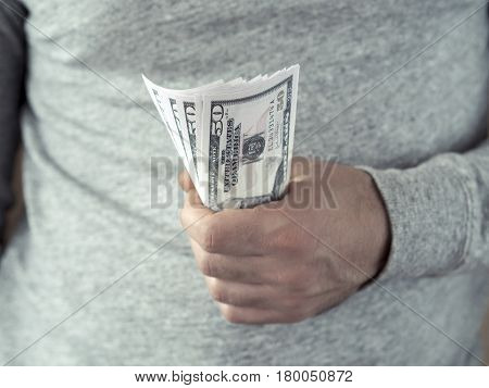 Hands hold dollars. Selective focus. Shallow DOF