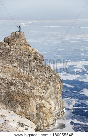 Traveler on top of the island's Oltrek cape Lake Baikal. Winter landscape
