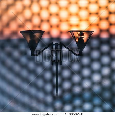 View of the lamppost at sunset through grate.