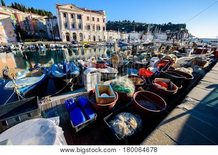 Piran Slovenia - January 7 2017: Fishing boats nets and other equipment for commercial fishing on the shore.