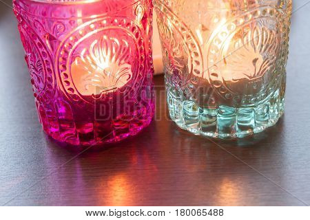 pink candle and light bule candle on a table .