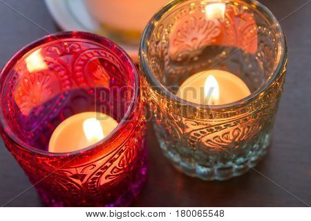 pink candle and light bule candle on a table .