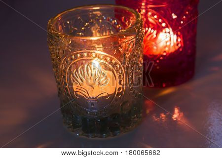 pink candle and light blue candle on a table .