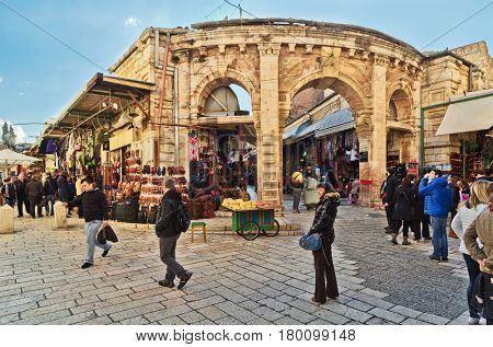 JERUSALEM, ISRAEL - DECEMBER 26, 2016: medieval gate leads to the Aftimos Bazaar with its noisy merchants and colorful goods in the Christian quarter of the old city of Jerusalem