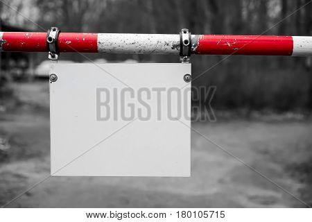 Barrier with a blank white signboard on a Road