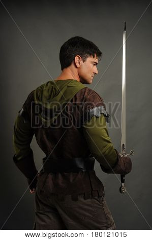 The desirable man is holding a sword.