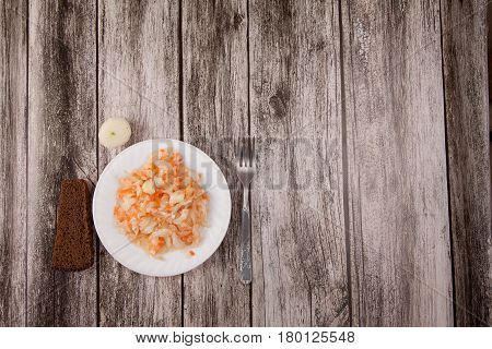 Sour Cabbage On A Plate And Black Bread On A Wooden Background
