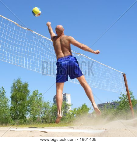 Kopasz ember játszik strand röplabda - háló felett Jumping