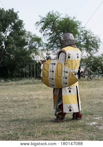 Medieval knight ready for battle, reenactment with costumed characters and medieval armor with chainmail, helmet swords and shields. Medieval demonstration and recreation