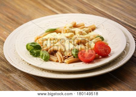 Portion of delicious pasta with cheese on wooden background