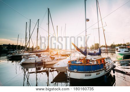 Riga, Latvia - July 1, 2016: Riga, Latvia. Many Yachts Moored At The City Pier Harbour Bay And Quay In Summer Sunny Evening. Reflections From Boats In Water Of Western Dvina River.