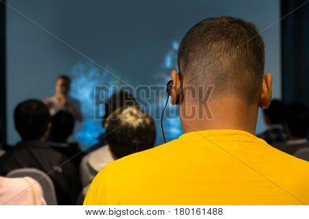 The Male Audience At International Business Meeting Or Seminar Wearing Headphone For Online Translat