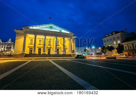 Vilnius, Lithuania. Main Facade Of Town Council In Evening Illumination, Administrative Building With Columns On Didzioji Street In Old Town Under Summer Blue Sky.