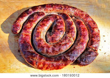 Delicious Sausages On Wooden Plate Cooked On Barbecue Grill