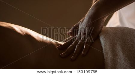 Massage closeup view with hands of professional masseur. Charming lighting