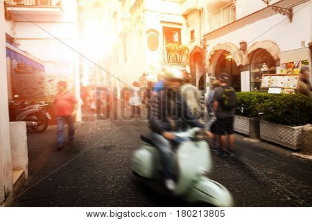 man riding scooter motorcycle in amalfi street south italy most popular traveling destination