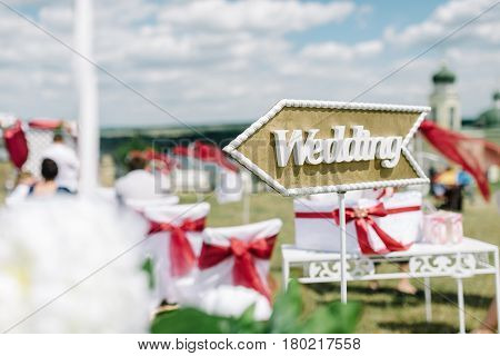 Wedding decor. Wooden plaque with the inscription Wedding. Wedding on a plate green background and a fountain. Wedding decorations