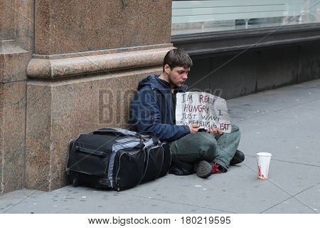 NEW YORK - APRIL 4, 2017: Homeless man in front of Macy's store in Midtown Manhattan