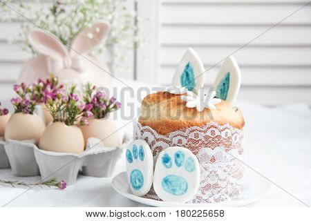 Easter cake in the form of the Easter Bunny and Easter decor with flowers on the table
