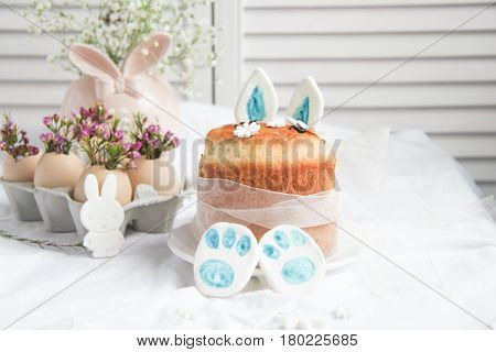 Easter cake in the form of the Easter Bunny and Easter decor with flowers on the table