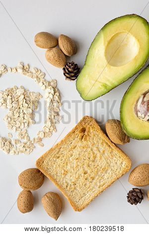 Sliced avocado oats toast and whole almonds view from above white background breakfast