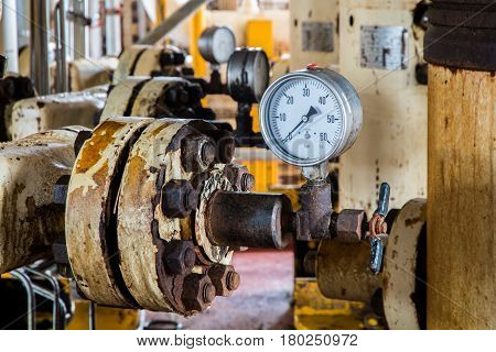 Closeup of pressure gauge pressure gauge measuring gas pressure. Pipes and valves at oil and gas industrial plant.
