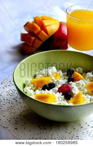 Still life suggest, cottage cheese with berries and mango, mango and juice.