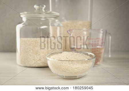 Kitchen ware with rice and water on wooden table