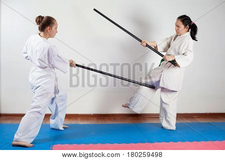 Two girls demonstrate martial arts working together. Fighting position active lifestyle practicing fighting techniques