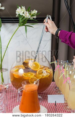 Fresh juice on a table in a restaurant. Healthy drinks. carrot fresh in a jar. Girl pouring juice.