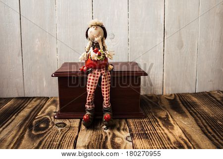 toy redhood sitting on wooden box wood background