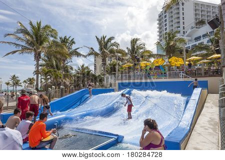 Hollywood Beach Fl USA - March 13 2017: People are surfing on the FlowRider surf simulator in Hollywood Beach broadwalk. Florida United States