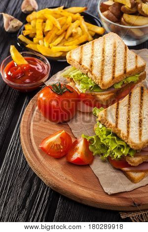 Club Sandwich With Tomato, Lettuce, Bacon, Ham And French Fries