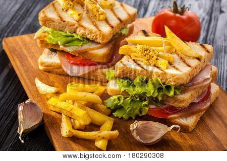 Club Sandwich With Tomato, Lettuce, Bacon, Ham And French Fries