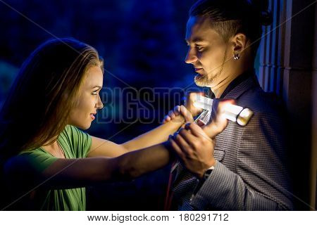 Young people have fun on nature background. She fights him. He stares at her. Couple have fun.
