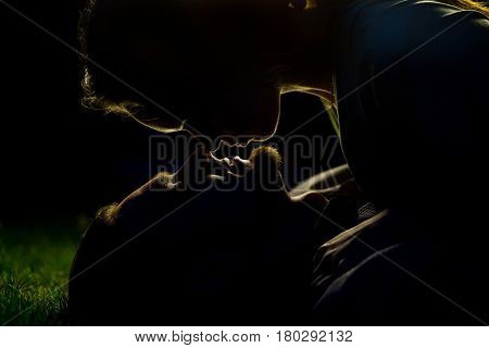 Passion couple silhouette in the night. Lovely summer evening. Young people feed warm feelings to each other. Nice love story.