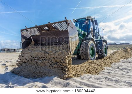 Kijkduin the Netherlands - April 6 2017: Tractor Front End Loader moving sand