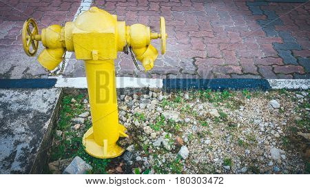 Yellow fire hydrant on street. Typical yellow fire hydrant asian on street. Yellow fire Hydrant vintage style.