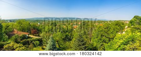 Distant and panoramic view of Sapanca Lake and a village house surrounded by trees on a sunny day