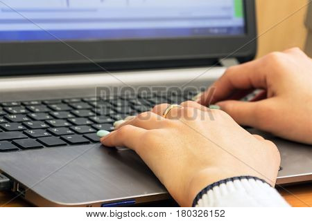 Woman's hand on laptop keyboard. Selective focus