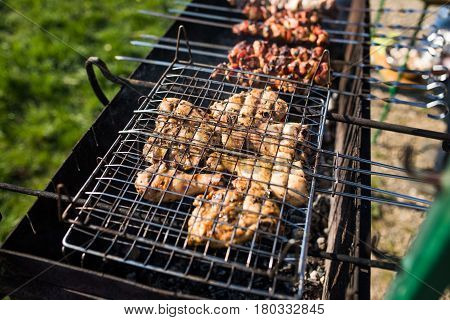 Closeup Of Some Meat Skewers Being Grilled In A Barbecue. Grilling Marinated Shashlik On A Grill.