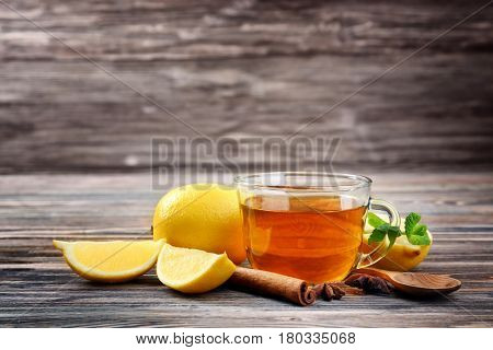 Hot drink with honey and lemon for cough remedy on wooden table
