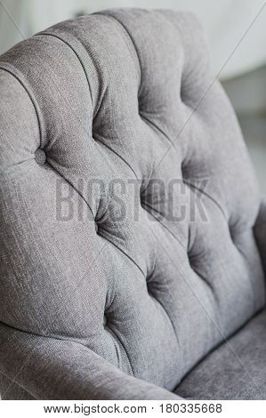 Seamless background texture close up of a grey sofa back with button detail on a thick cloth